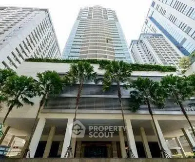 Stunning high-rise building with modern architecture and lush greenery in urban setting.