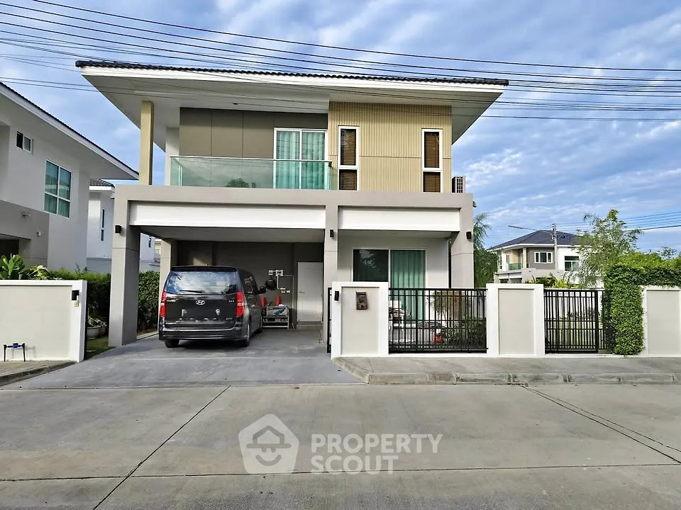 Modern two-story house with spacious driveway and sleek design in a suburban neighborhood.