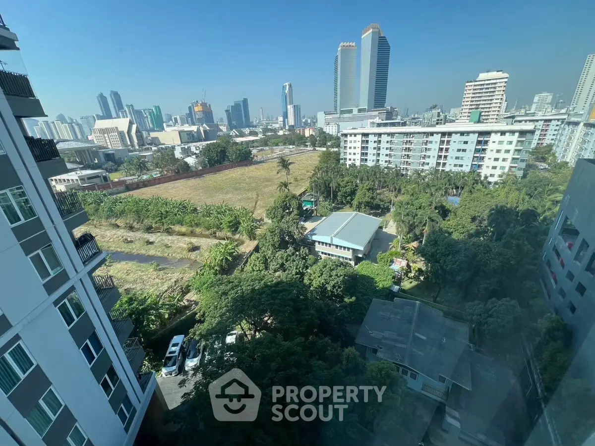 Stunning cityscape view from a high-rise apartment with lush greenery and urban skyline.