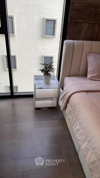 Modern bedroom with large window and stylish decor in urban apartment