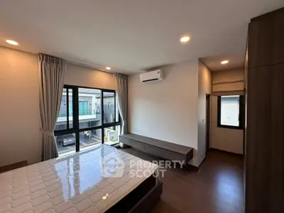 Spacious modern bedroom with large windows and sleek wooden flooring