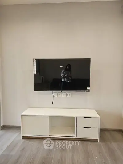 Modern living room with wall-mounted TV and sleek white console