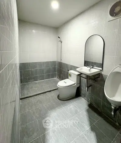 Modern bathroom with sleek gray tiles and minimalist fixtures.