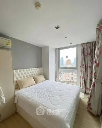 Cozy bedroom with city view, featuring a plush bed and modern decor, perfect for urban living.