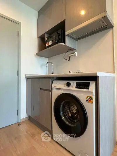 Modern compact kitchen with washing machine and sleek cabinetry