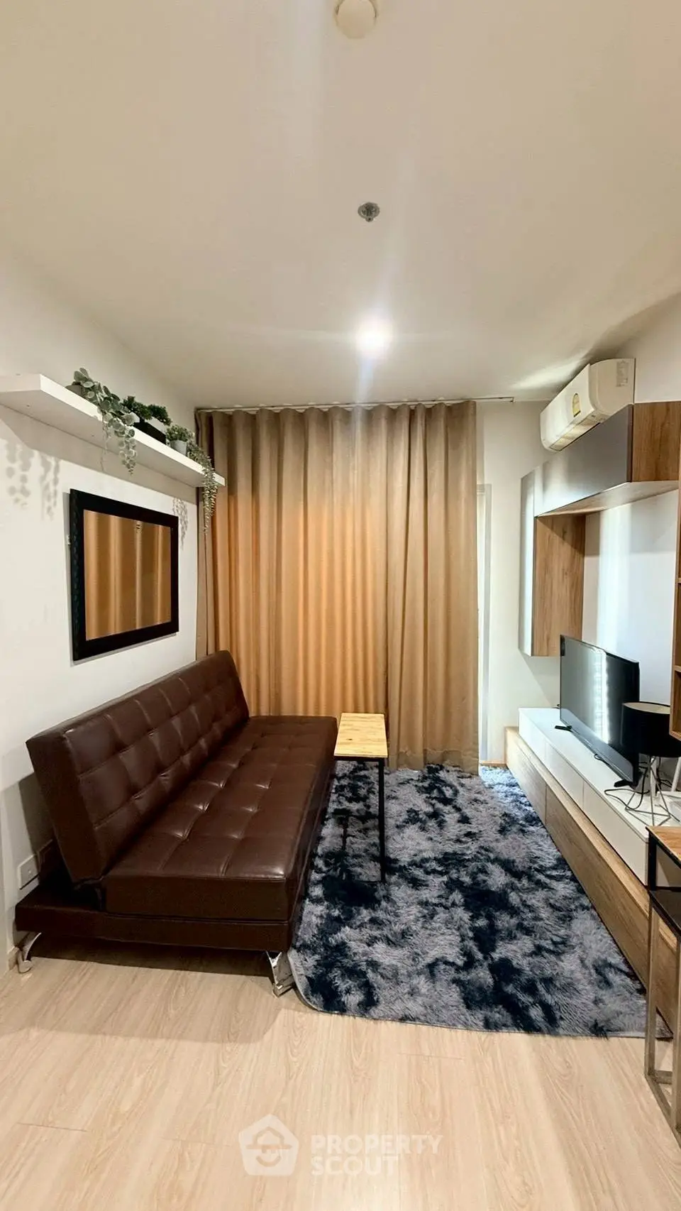 Modern living room with brown leather sofa, stylish decor, and cozy ambiance.
