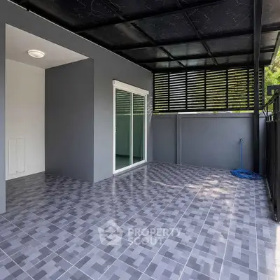 Modern covered patio with sleek tile flooring and sliding glass doors