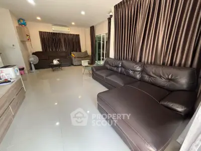 Spacious living room with modern leather sofas and elegant curtains