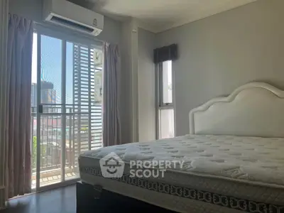Bright bedroom with large window and balcony access in modern apartment