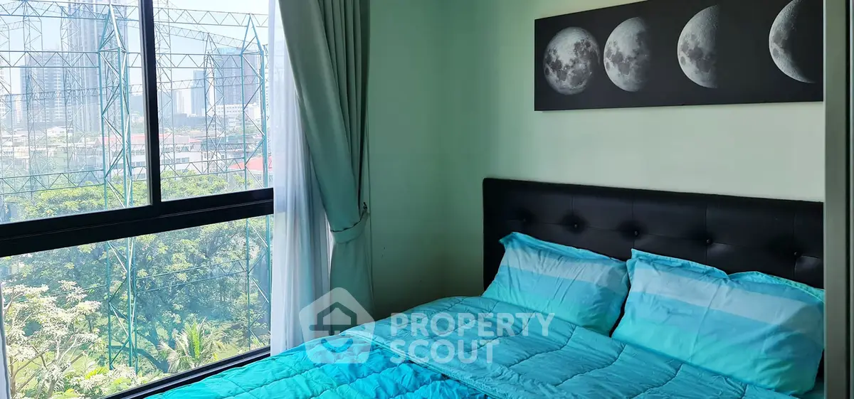 Cozy bedroom with city view and modern decor, featuring a moon phase artwork above the bed.