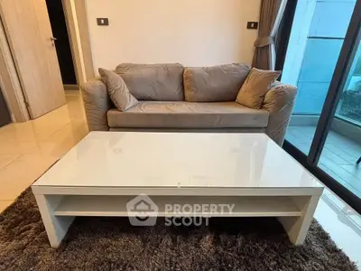 Modern living room with cozy sofa and sleek coffee table near large glass doors.