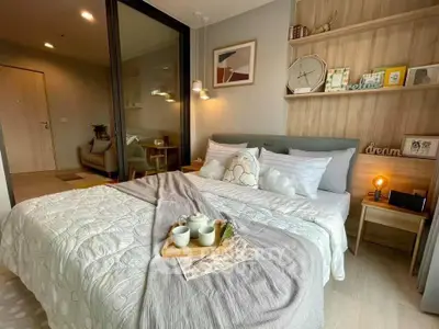 Cozy bedroom with modern decor and inviting ambiance, featuring a comfortable bed and stylish shelving.