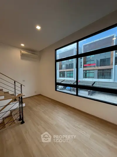 Spacious modern living room with large windows and wooden flooring