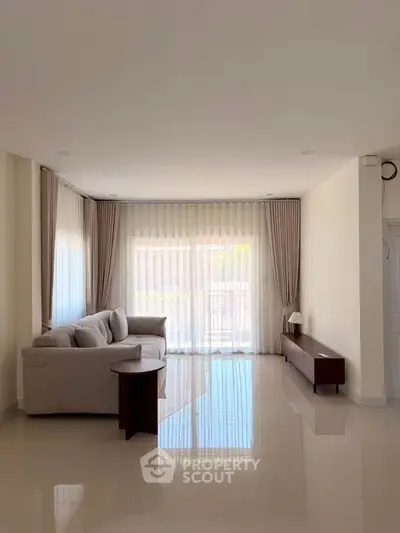 Spacious living room with elegant curtains and modern furniture, perfect for relaxation and entertaining.