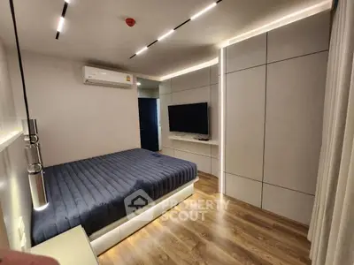 Modern bedroom with sleek design, featuring a wall-mounted TV and stylish lighting.
