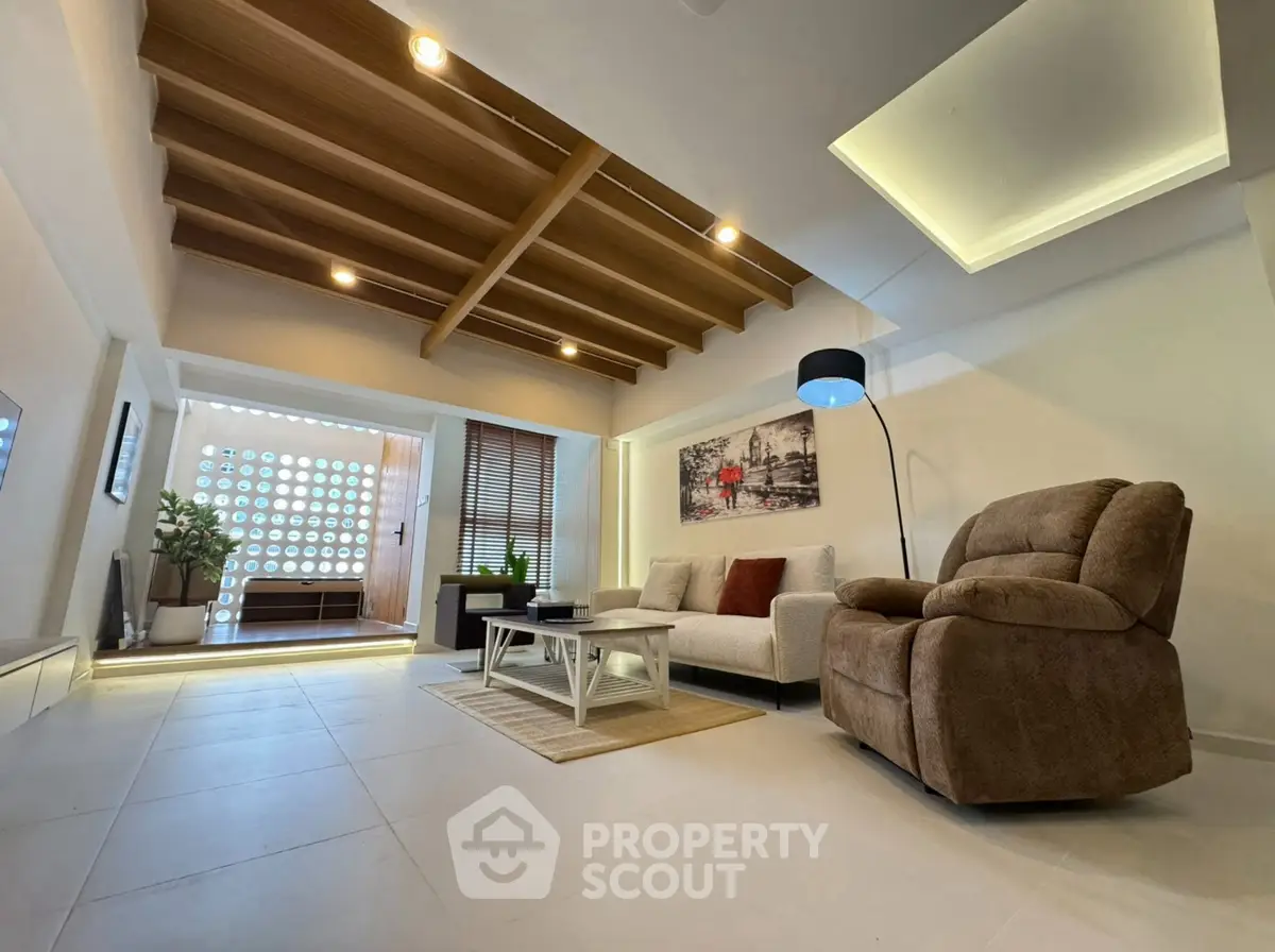 Spacious modern living room with stylish ceiling and cozy seating area.