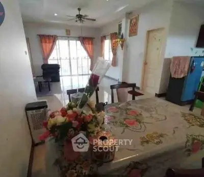 Charming dining area with floral tablecloth and cozy living room view