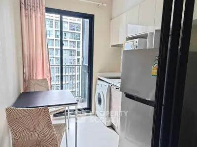Modern compact kitchen with washing machine and balcony view in urban apartment