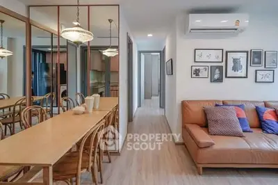 Modern living room with stylish decor and open layout, featuring a cozy leather sofa and elegant dining area.