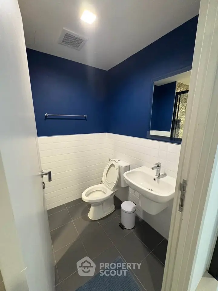 Modern bathroom with blue accent wall and sleek fixtures
