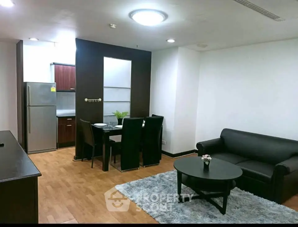 Modern living room with open kitchen, sleek furniture, and cozy ambiance in a stylish apartment.