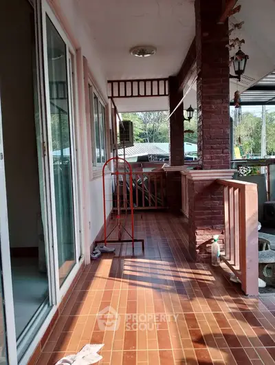 Spacious balcony with brick accents and sliding glass doors, perfect for relaxation.