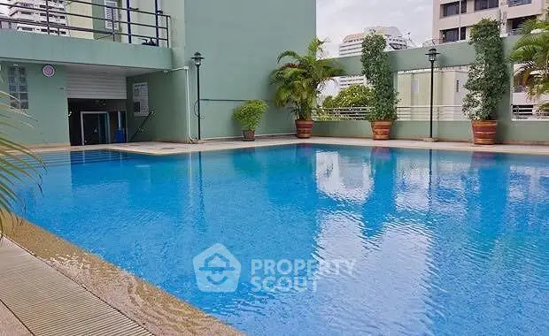 Luxurious residential pool area with lush greenery and modern architecture.