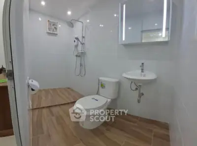 Modern bathroom with sleek fixtures and wooden floor tiles