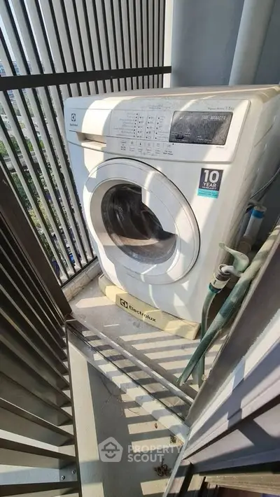 Compact balcony with washing machine, ideal for urban living convenience.