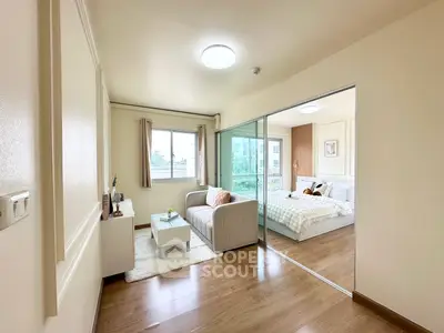 Modern studio apartment with cozy living area and bedroom, featuring wooden flooring and ample natural light.