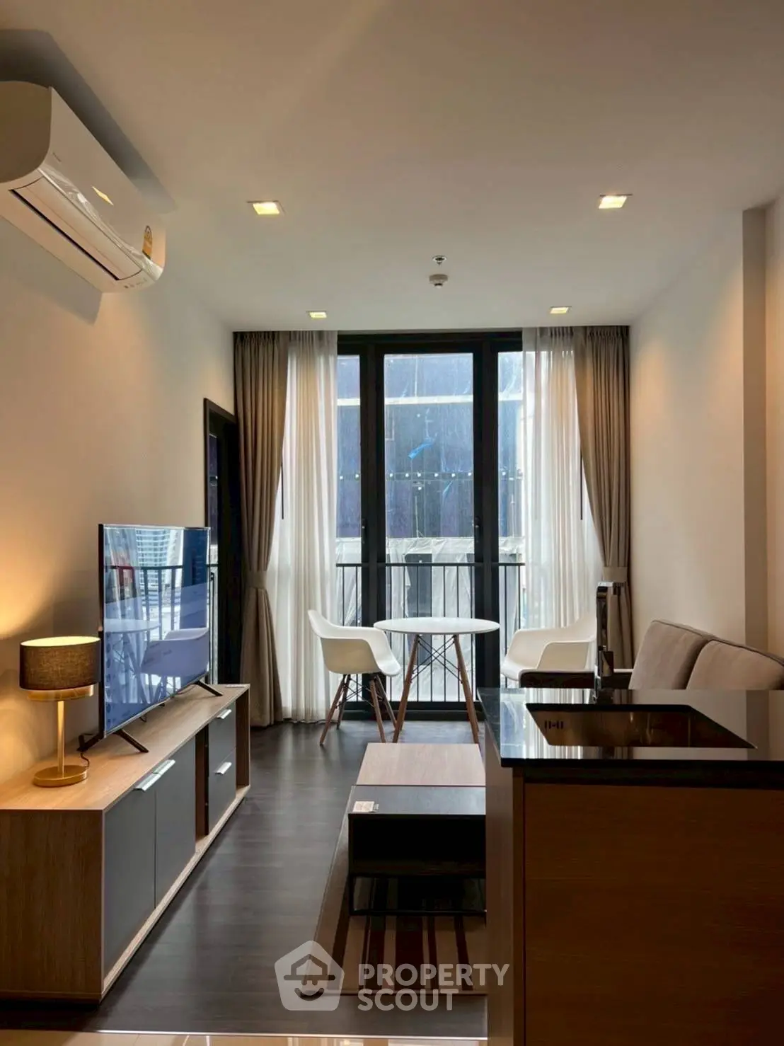 Modern living room with sleek furniture and large windows for natural light.