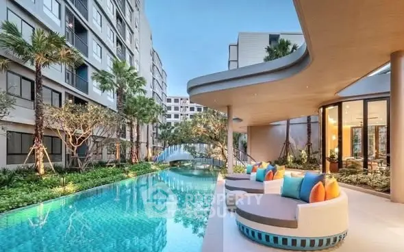 Luxurious apartment complex with stunning pool and modern outdoor seating area.