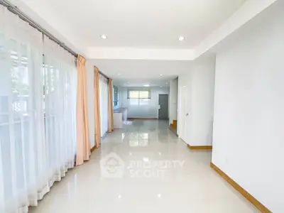 Spacious open-plan living area with large windows and natural light