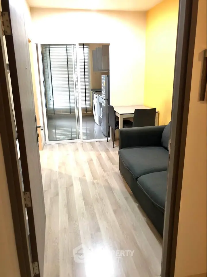 Modern apartment interior with cozy living area and washing machine in view.