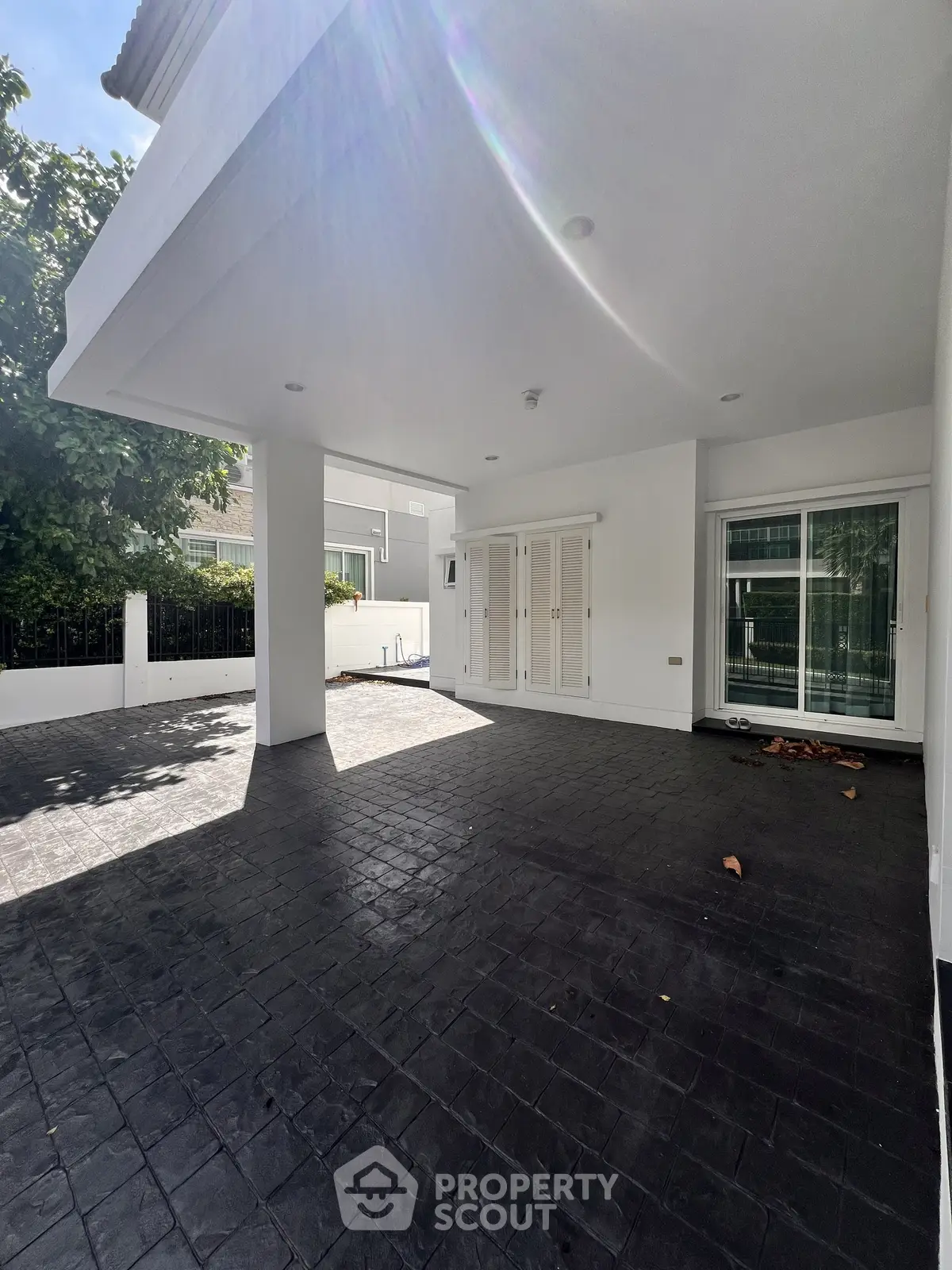 Spacious modern home exterior with covered patio and sleek design, perfect for outdoor relaxation.