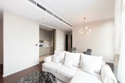 Modern living room with elegant sofa and open kitchen layout in a bright apartment.