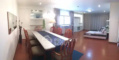 Spacious open-plan living and dining area with elegant wooden flooring and stylish furniture.