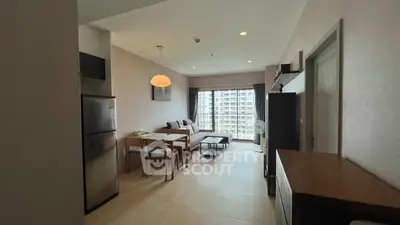 Spacious modern living room with dining area and large windows in a stylish apartment.