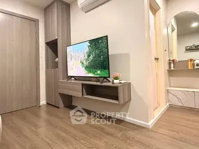 Modern living room with wall-mounted TV and stylish wooden flooring
