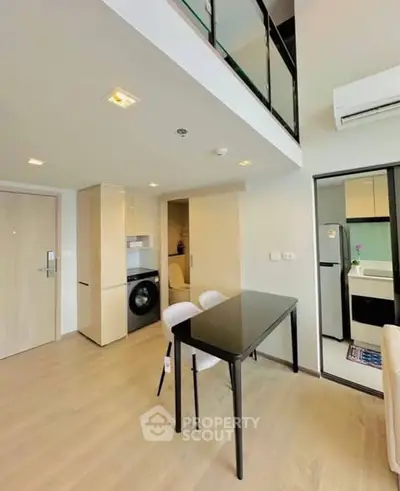 Modern open-plan apartment with sleek kitchen and dining area