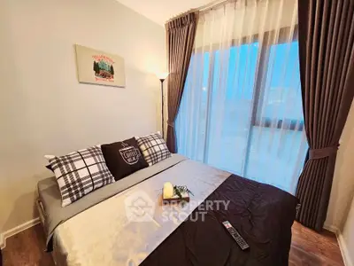 Cozy bedroom with large window and stylish decor, perfect for relaxation.