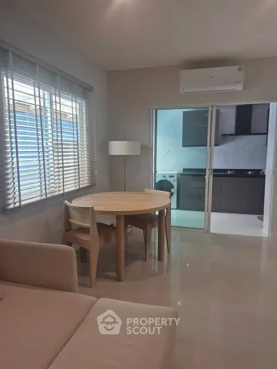 Modern living room with dining area and view into sleek kitchen