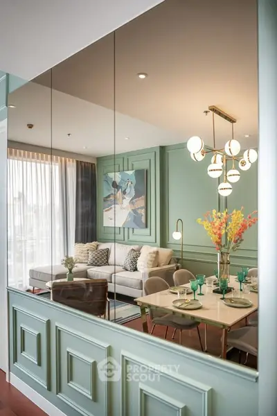 Elegant living room with stylish decor and dining area, featuring modern lighting and large windows.