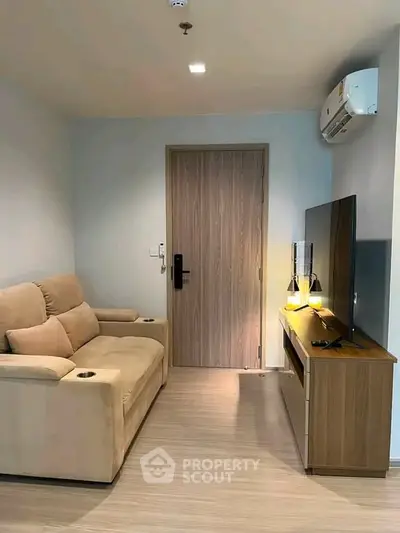Cozy living room with modern sofa and TV, perfect for relaxation.