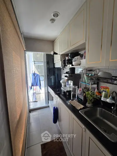 Compact kitchen with modern appliances and balcony access