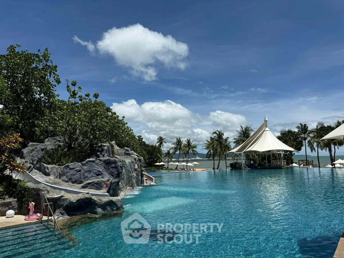 Luxurious resort-style pool with stunning ocean view and lush tropical landscaping.