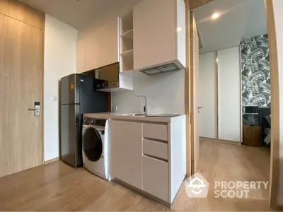 Modern compact kitchen with sleek appliances and wood flooring