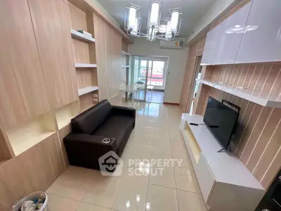 Modern living room with sleek furniture and large windows leading to a balcony, perfect for urban living.