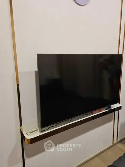 Modern living room with sleek wall-mounted TV and minimalist decor.