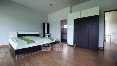 Spacious modern bedroom with sleek furniture and wooden flooring